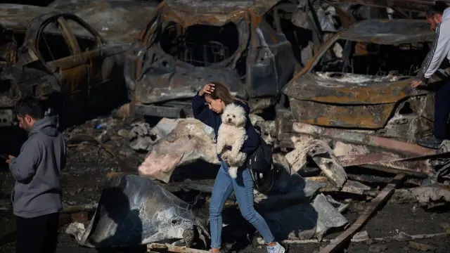A woman holds her dog as she walks past burned cars a day after an Israeli airstrike in Beirut, Lebanon, Thursday, April 9, 2026. (AP Photo/Emilio Morenatti)Associate Press/ LaPresseOnly Italy and SpainAssociate Press/ LaPresseOnly Italy and Spain