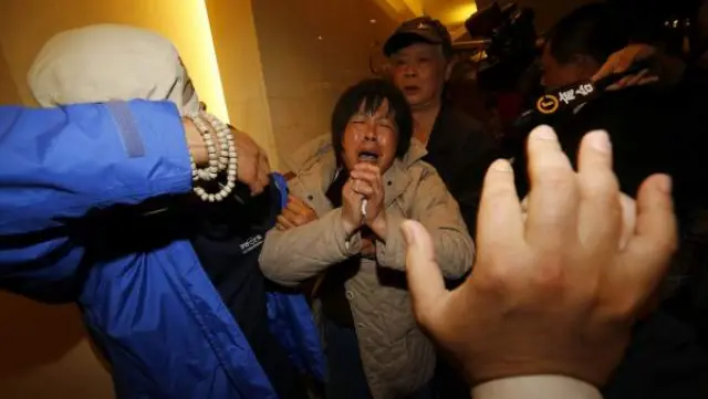 Familiares de pasajeros del avión de la compañía Malaysia Airlines desaparecido con 239 personas a bordo el pasado 8 de marzo, lloran tras conocer que se estrelló en el mar, en el sur del océano Índico, en Pekín, China.