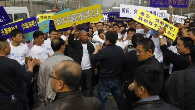 Familiares de los pasajeros del vuelo MH370 de Malaysia Airlines son bloqueados por la policía en su intento de alcanzar la embajada de Malasia en Pekín.