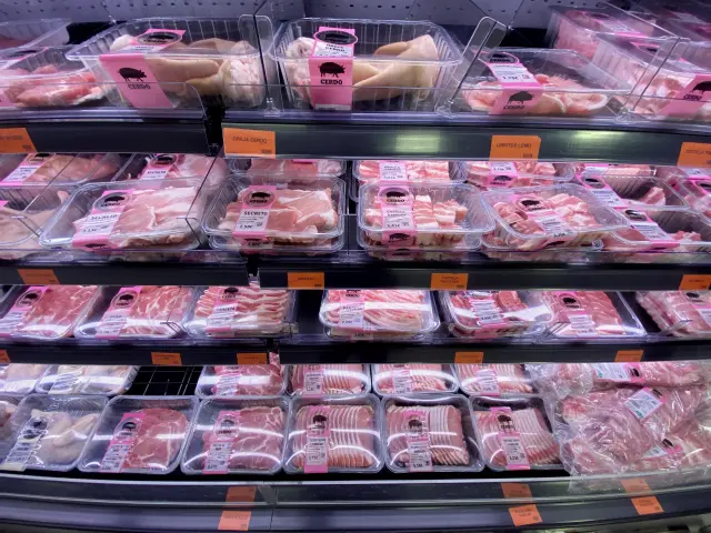 Neveras con carne envasada en la sección de carnicería de un supermercado