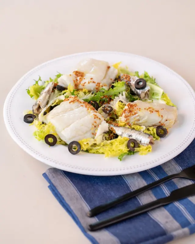 Ensalada de escarola con solomillos de bacalao desalado y aceitunas negras