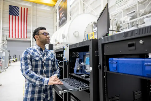 Adrian Johnson, químico del aire en el Centro Marshall de Vuelos Espaciales de la NASA en Huntsville, Alabama, opera el Micro-GC, que se utiliza para medir los niveles de monóxido de carbono, durante una prueba del sistema de control de contaminantes traza en la cámara ambiental.