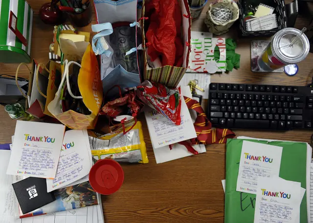 Imagen de archivo de una mesa de escuela repleta de regalos y cartas de agradecimiento.