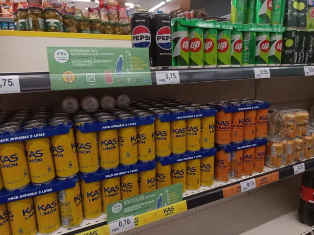 Carteles en los lineales de bebidas del supermercado informando del cobro de la fianza, que se recupera en el momento de la devolución.