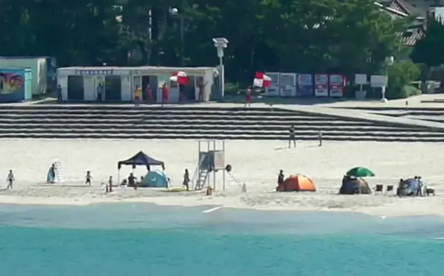 Imagen de una playa en Japón con banderas de alerta de tsunami, a 30 de julio de 2025.