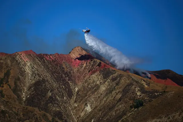 CASTAIC (United States), 08/08/2025.- A helicopter does a water drop on the Canyon Fire as it burns on brush-filled hillsides in Castaic, California, 07 August 2025. The Canyon Fire near Lake Piru, a reservoir about 60 miles northwest of downtown LA, has forced thousands to evacute and has grown to more than 1,000 acres according to Cal Fire. EFE/EPA/ALLISON DINNER
