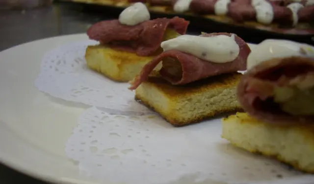 Plato con tapas de lengua a la escarlata.