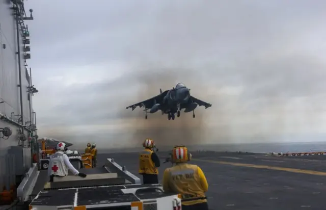 Un AV-8B Harrier aterriza en la cubierta de un USS Iwo Jima.