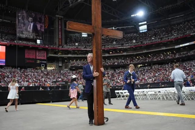 El tono del memorial tuvo un gran sentido religioso; en la foto, un seguidor sostiene una enorme cruz de madera.