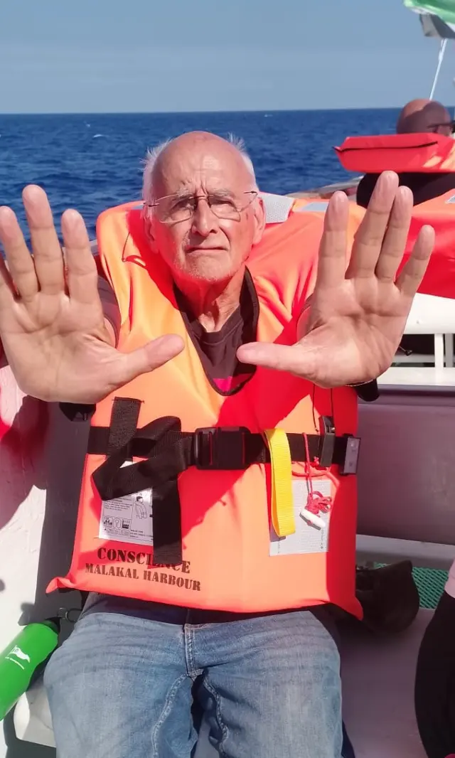 José Lozano, con las manos extendidas durante un simulacro a bordo sobre la forma no violenta de enfrentar el abordaje de los militares israelíes.