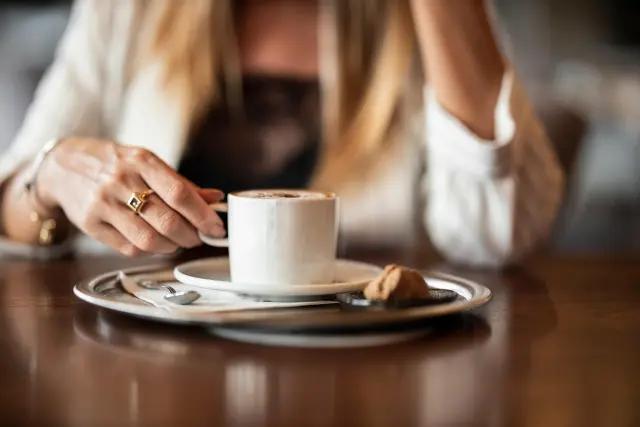 Una mujer desayuna una taza de café, en una imagen de archivo.
