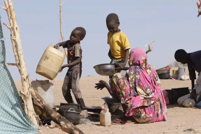 Niños ayudan a preparar comida en un campamento de desplazados en El Fasher, región de Darfur del Norte, Sudán, el 9 de julio de 2025.
