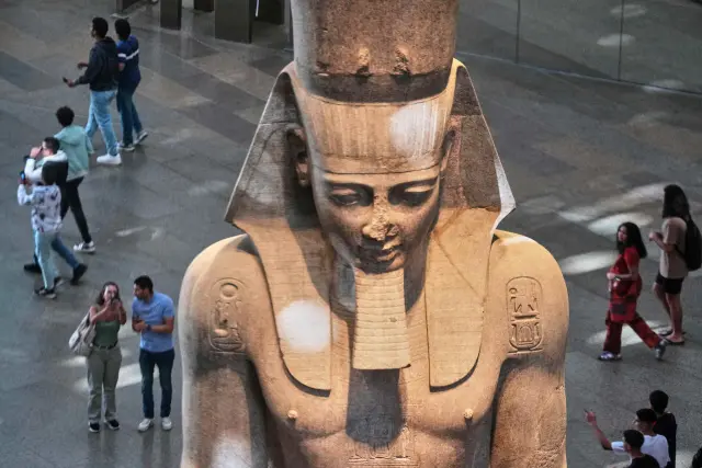 Tourists view the statue of Pharaoh Ramses II, during the first day for visitors after the official opening of the Grand Egyptian Museum in Giza, Egypt, Tuesday, Nov. 4, 2025. (AP Photo/Amr Nabil)