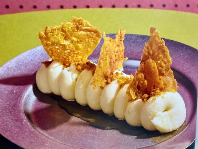 Puré de patata con piel de pollo crujiente y trufa.