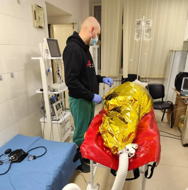 Un doctor trata a un paciente que ha sufrido una hipotermia .