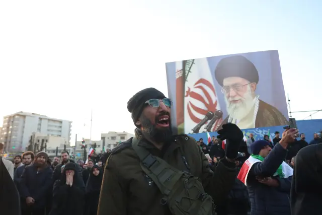 Un hombre con una pancarta de Jamenei sale a las calles de Teherán (Irán) tras conocerse la muerte del líder supremo.