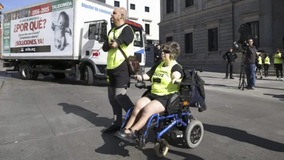 Un grupo de afectados por la talidomida que nacieron con deformaciones protesta a las puertas del Congreso de los Diputados.