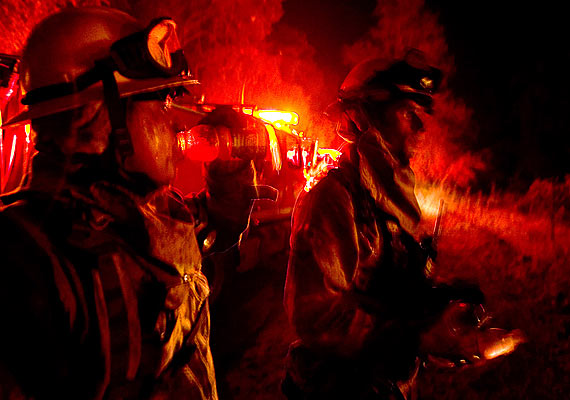 Lucha nocturna. Varios bomberos se toman un breve descanso para continuar en las labores de extinción de un incendio forestal al este de San Diego, California (EEUU).