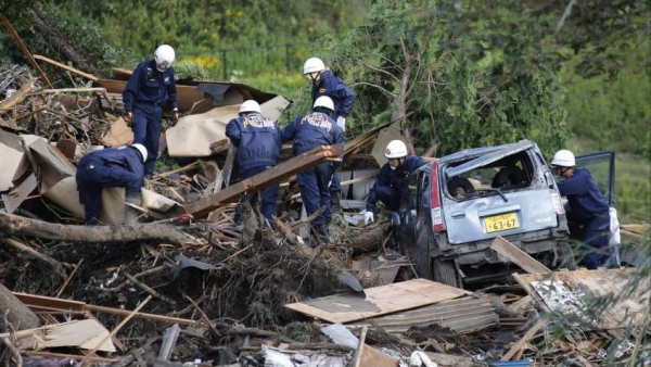 Bomberos de la isla Oshimabuscan supervivientes tras el paso del tifón Wipha en 2014.