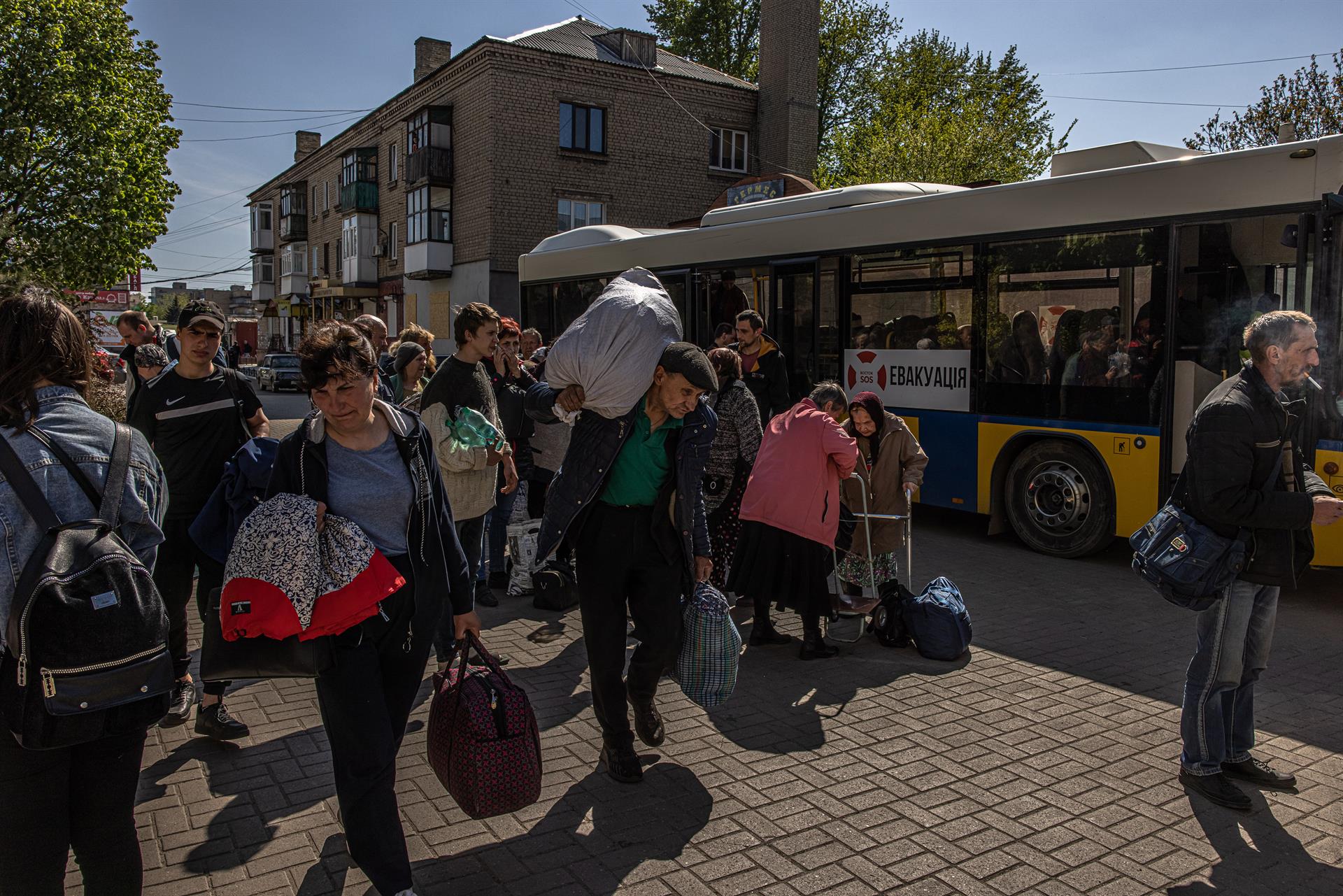 Ucranianos con su equipaje caminan hacia una estación de tren en Donetsk.