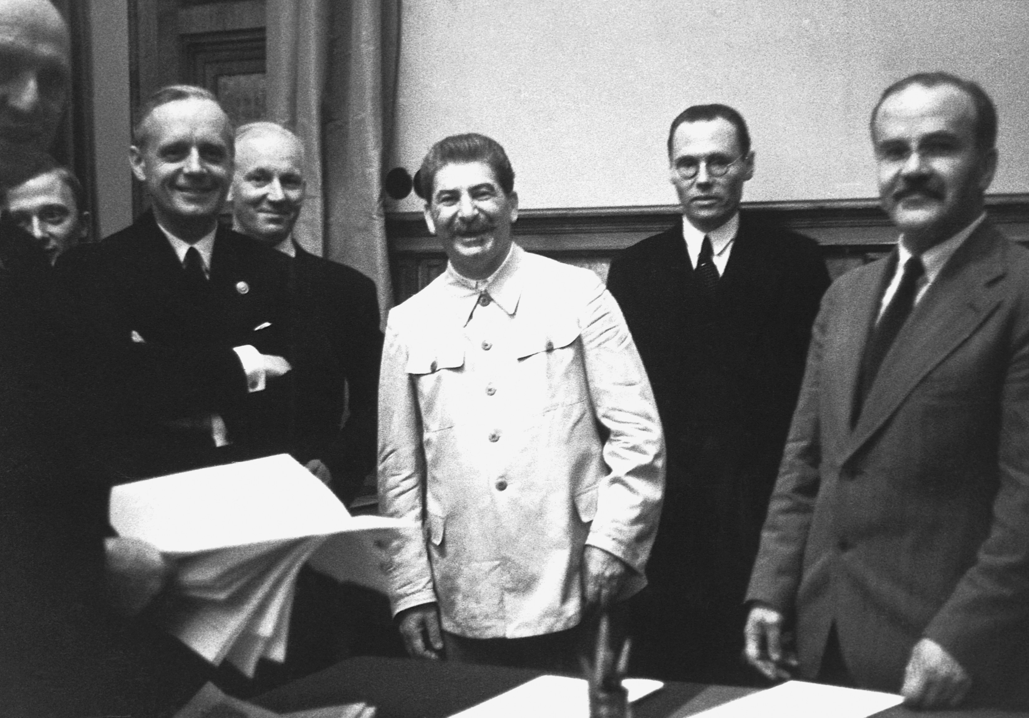 Stalin, sonriente en el centro, con Molotov y la comitiva de Ribbentrop, tras firmar el pacto de no agresión con la Alemania nazi en agosto de 1939.