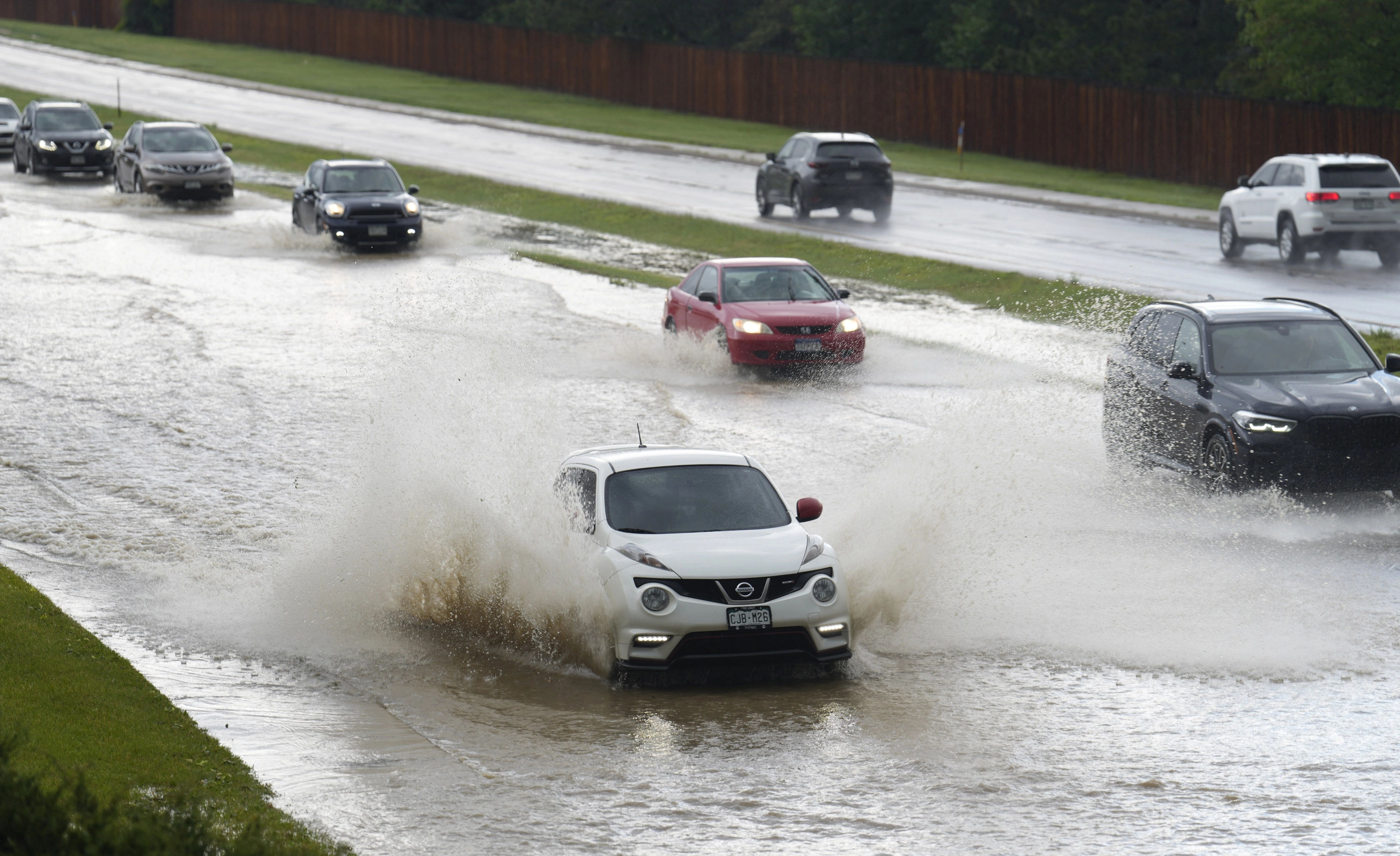 Los automovilistas atraviesan los carriles inundados en dirección este de County Line Road después de que una tormenta de verano con fuertes vientos, granizo, lluvias torrenciales e incluso un tornado azotara el suburbio de Lone Tree, al sur de Denver, Colorado.