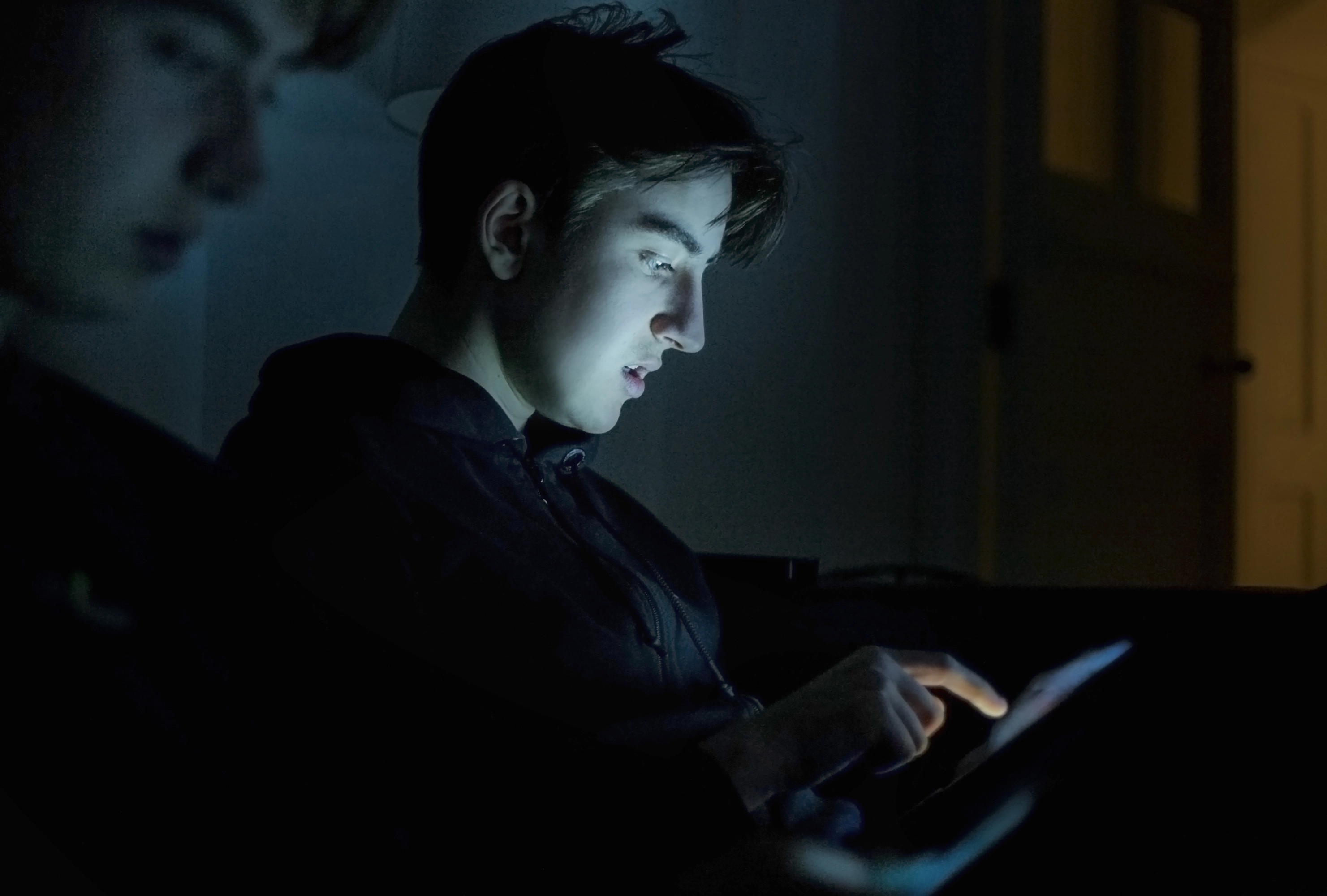 Foto de archivo de un joven usando el ordenador en su habitación.