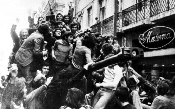 Gente festejando sobre un carro de combate en Lisboa durante la Revolución de los Claveles.
