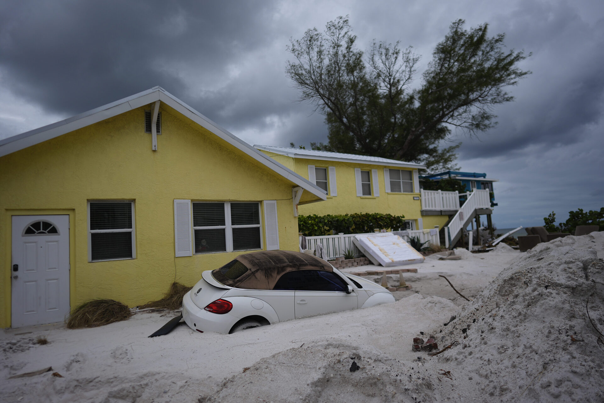 A car sits half-buried in sand as Bradenton Beach, Fla., which was in the process of cleaning up after Hurricane Helene, as Hurricane Milton approaches on Anna Maria Island, Tuesday, Oct. 8, 2024. (AP Photo/Rebecca Blackwell) associated Press / LaPresse Only italy and Spain