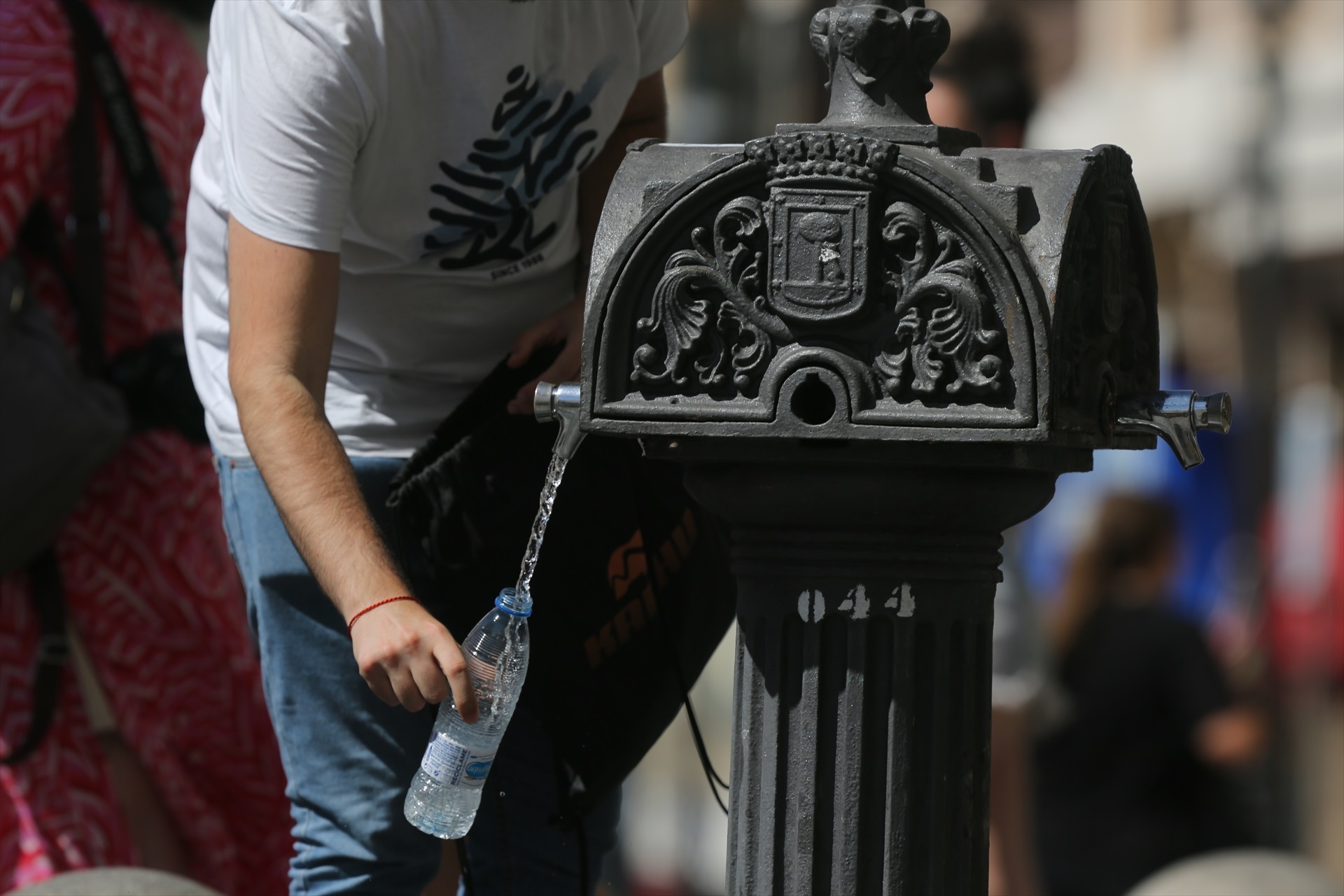 Una persona coge agua de una fuente de Madrid en una foto de archivo.