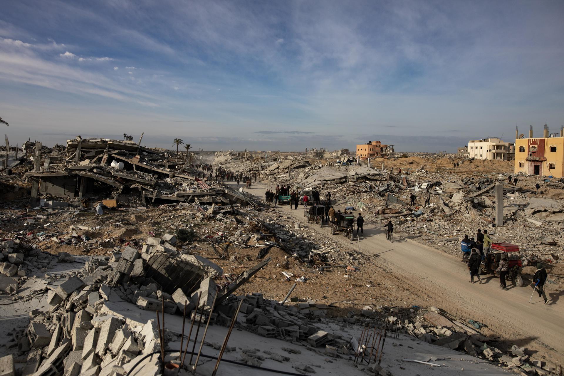 Palestinos desplazados internos caminan por una carretera en su camino hacia Rafah mientras abandonan las zonas cercanas a Jan Yunis, donde se habían refugiado, en el sur de la Franja de Gaza.