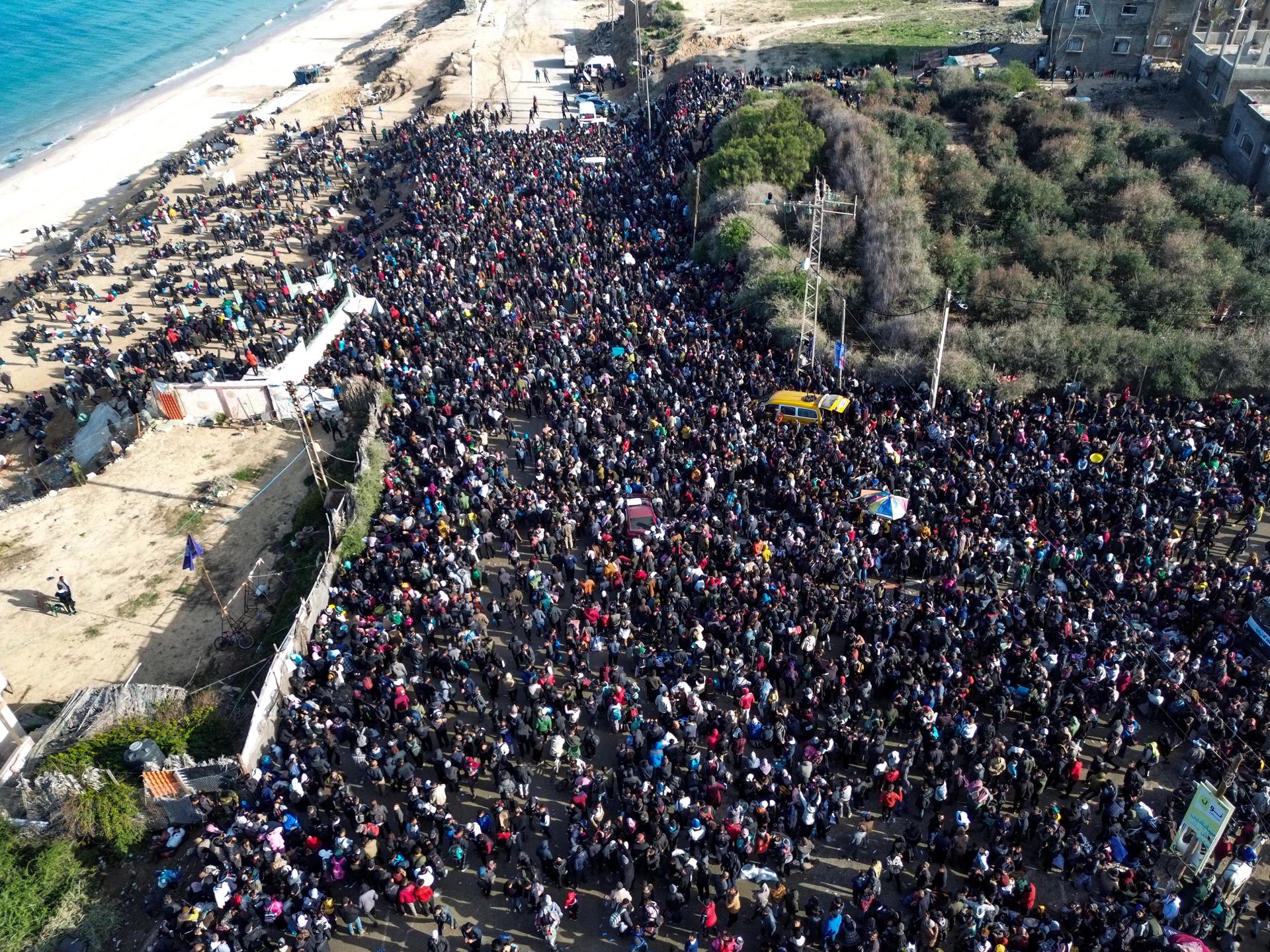 Fotografía tomada con un dron muestra a familias palestinas esperando para volver al norte de la Franja de Gaza desde el sur, a lo largo de la carretera Rashid.