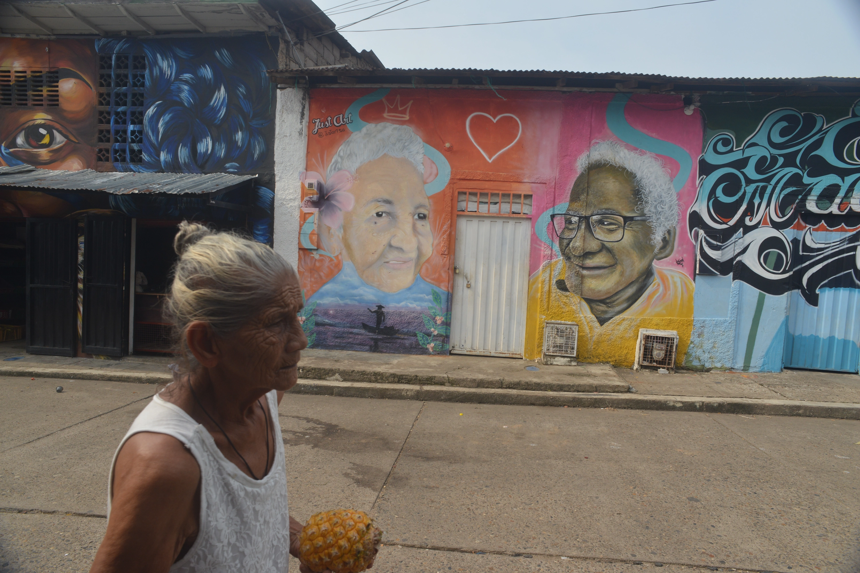 Una señora camina por San Pablo ante un mural.
