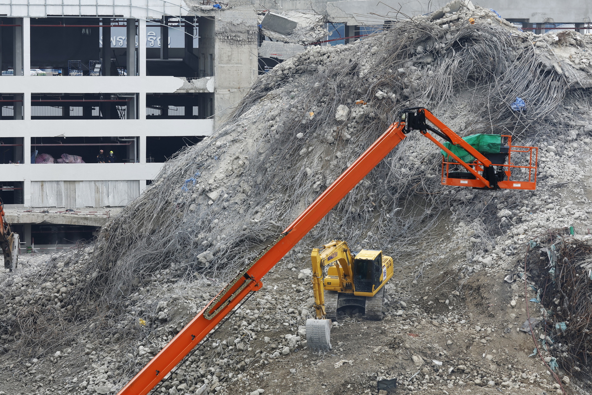 Bangkok (Thailand), 11/04/2025.- Excavators operate as rescuers search for survivors at the site of a collapsed building in Bangkok, Thailand, 11 April 2025. Rescue teams detected signs of life beneath the debris of a 30-storey building that collapsed following tremors from a 7.7-magnitude earthquake that struck Myanmar on 28 March. Workers from the Phetkasem Foundation reported detecting a mobile phone signal under the rubble and locating two bodies using radar scans, fueling hopes they may still be alive. (Terremoto/sismo, Birmania, Tailandia) EFE/EPA/NARONG SANGNAK