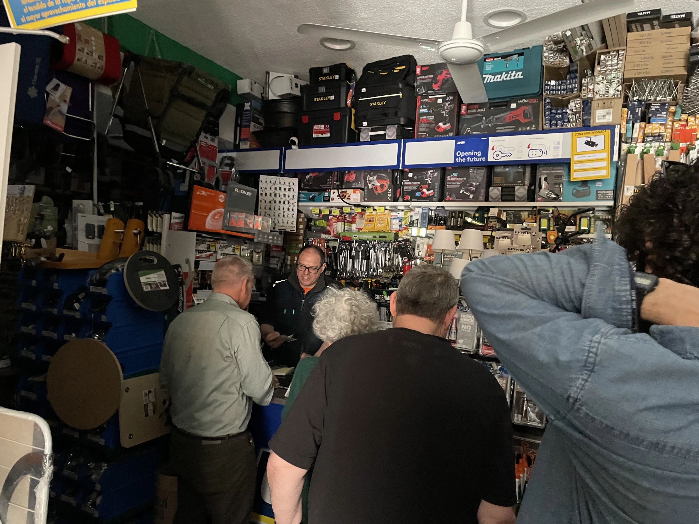 Clientes en el interior de la ferretería tras el apagón.