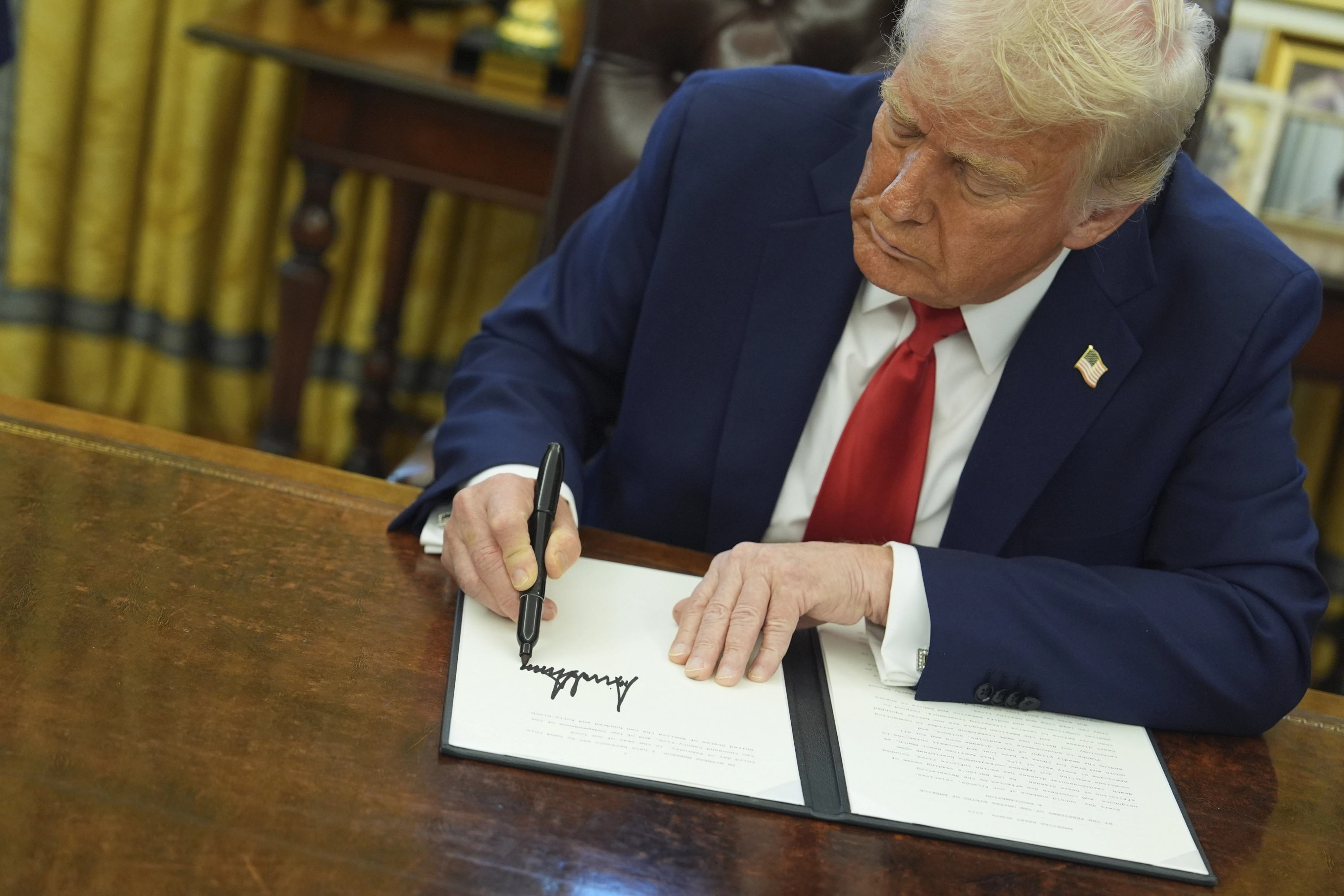 El presidente de Estados Unidos, Donald Trump, firmando un decreto en la Casa Blanca.