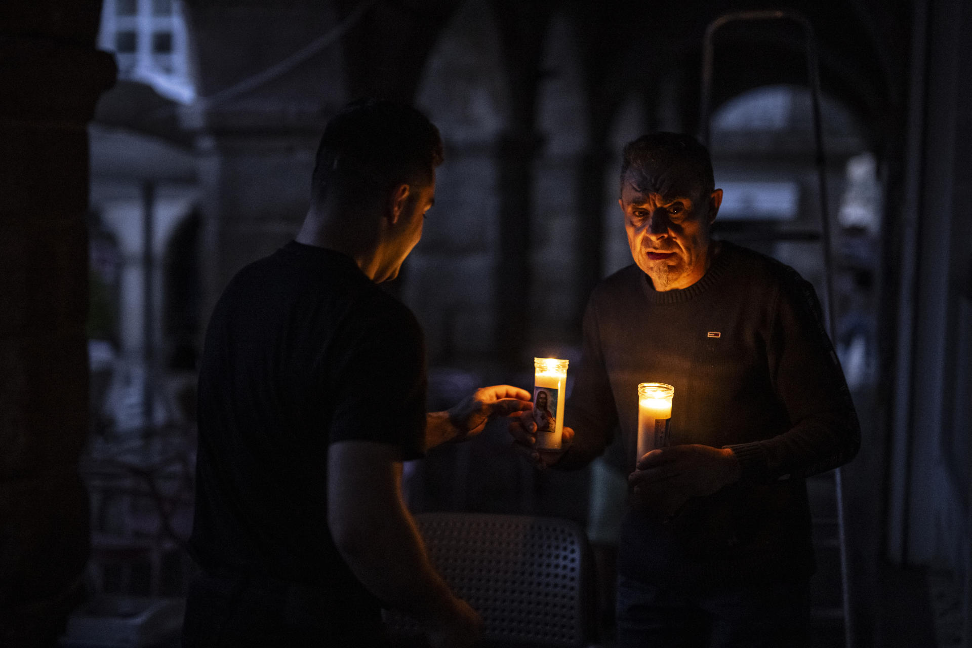 Dos personas iluminadas por la luz de las velas al caer la noche durante el apagón eléctrico en Ourense.