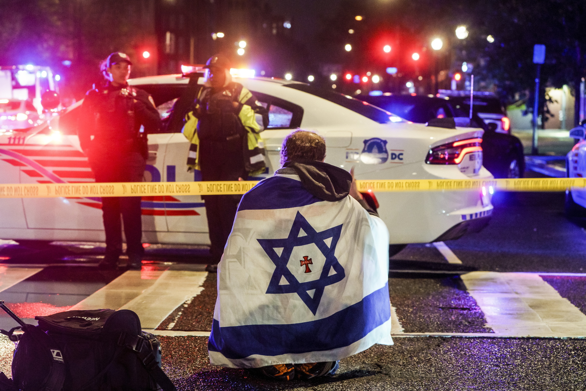 WASHINGTON (United States), 22/05/2025.- A man with an Israeli flag draped on his shoulders near the scene where two people were shot and killed near the Capital Jewish Museum in Washington, DC, USA, 22 May 2025. According to a social media post by the US Homeland Security Secretary Kristi L. Noem, the two people killed were staff members at the Israeli embassy. EFE/EPA/WILL OLIVER