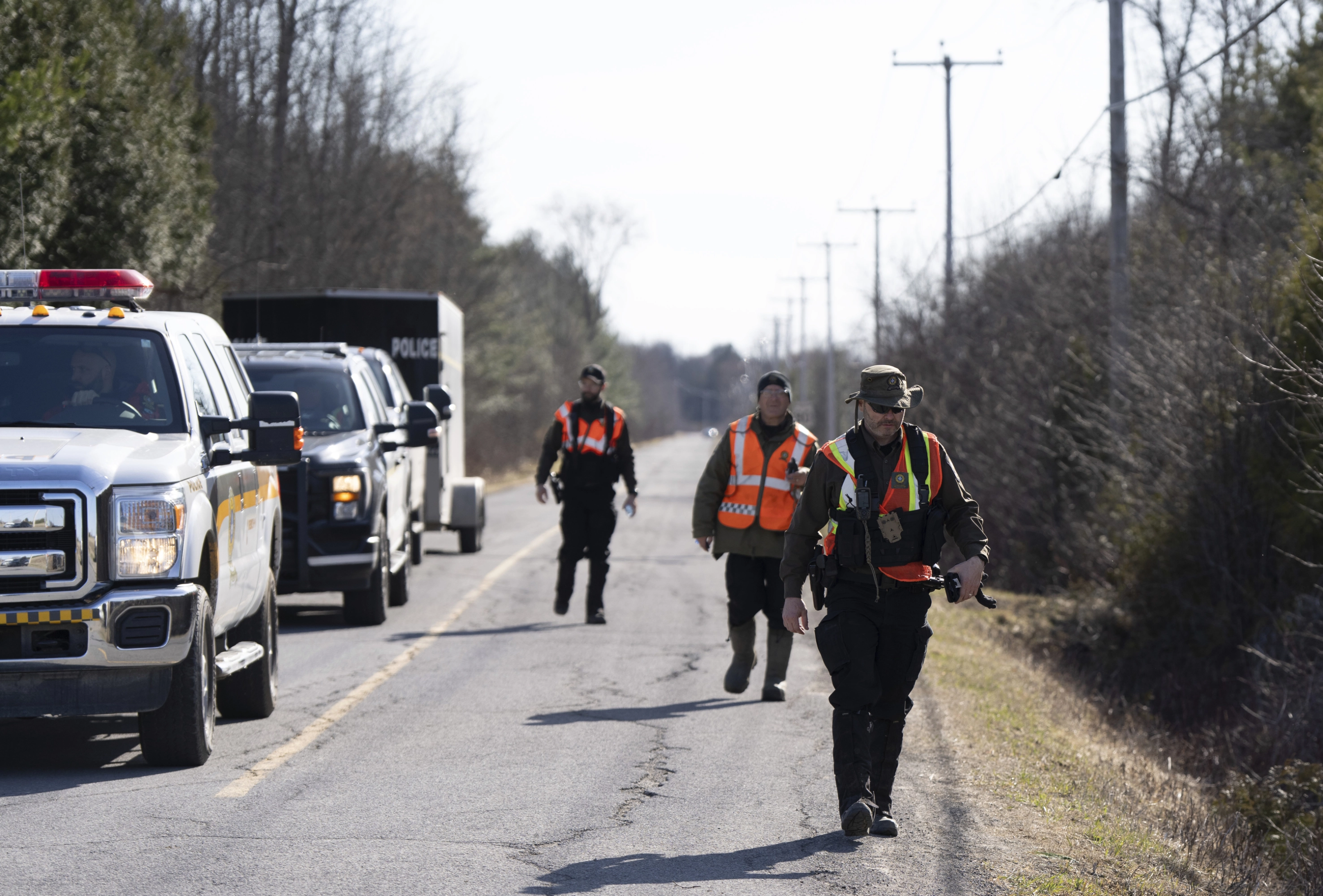 Agentes de la Surete du Quebec y de la Real Policía Montada de Canadá (RCMP) regresan a un puesto de mando tras buscar a inmigrantes que cruzan ilegalmente la frontera con Canadá.