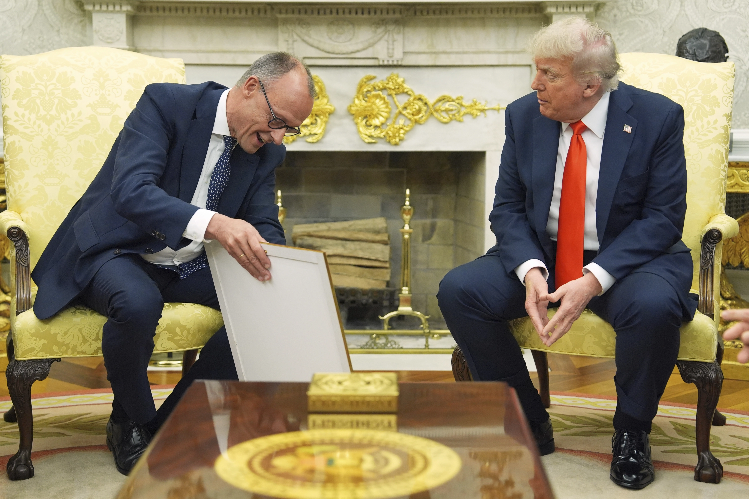 El canciller alemán Friedrich Merz regala al presidente Donald Trump el certificado de nacimiento de su abuelo.