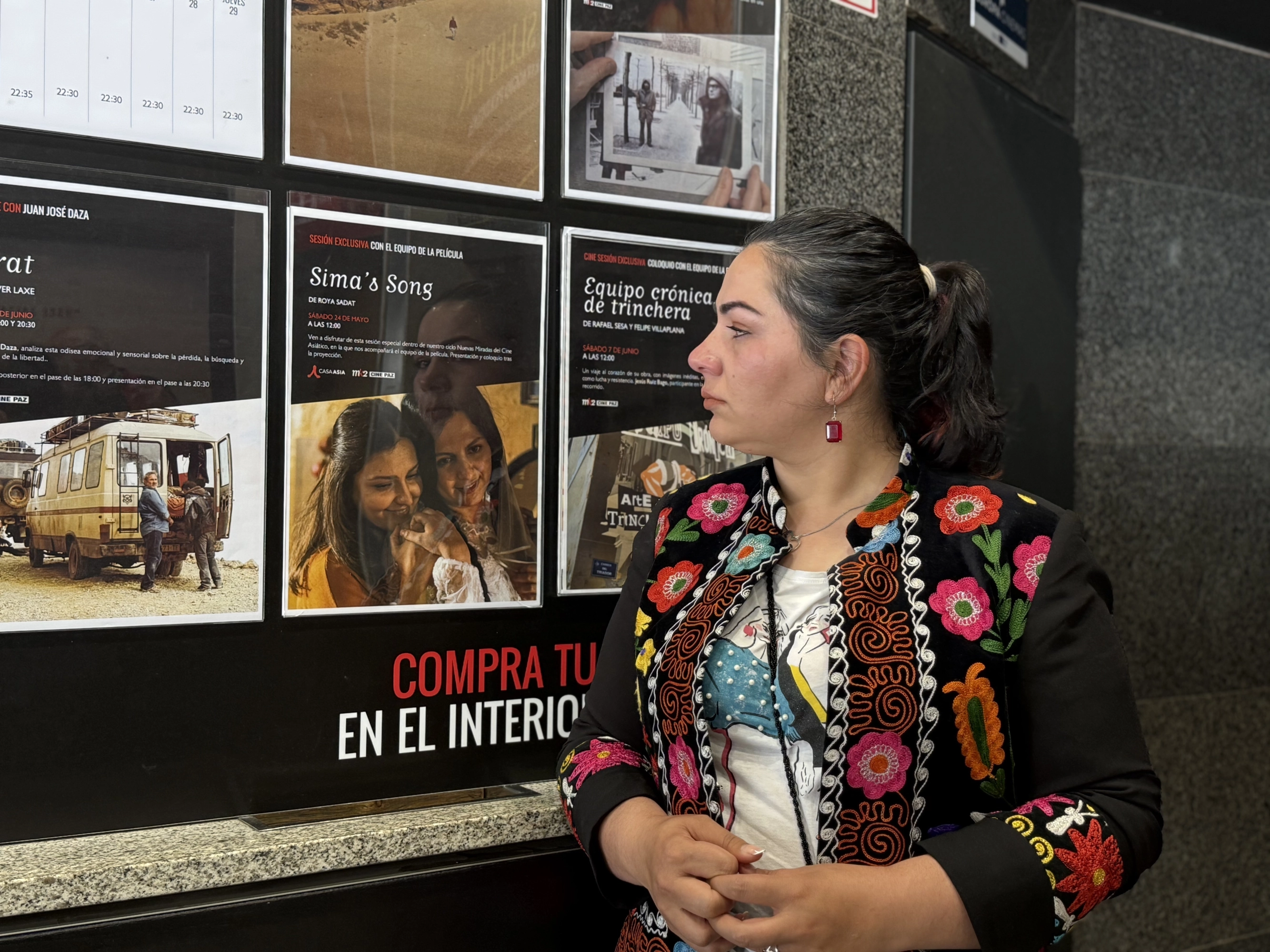 Khadija Amin mira el cartel de la película 'La Canción de Sima'.