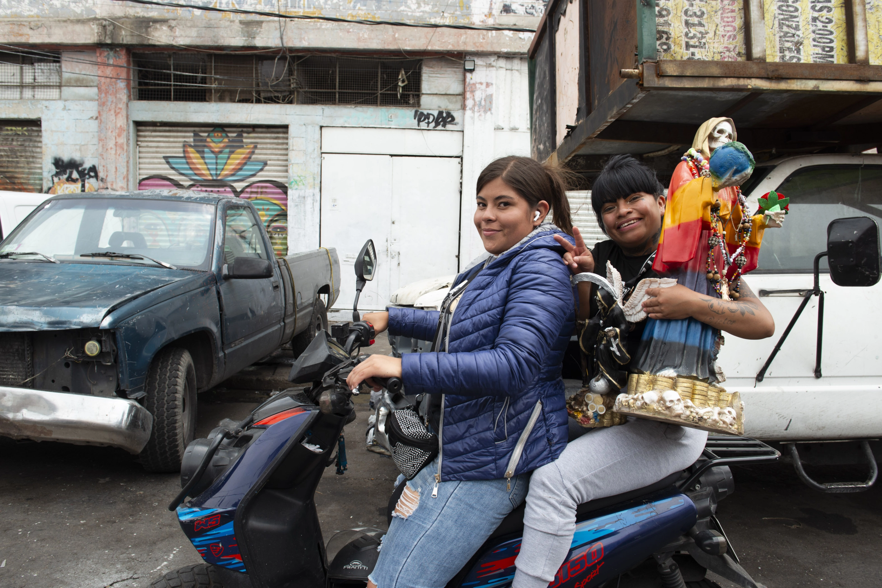 Dos jóvenes, en moto acompañadas de la Santa Muerte.