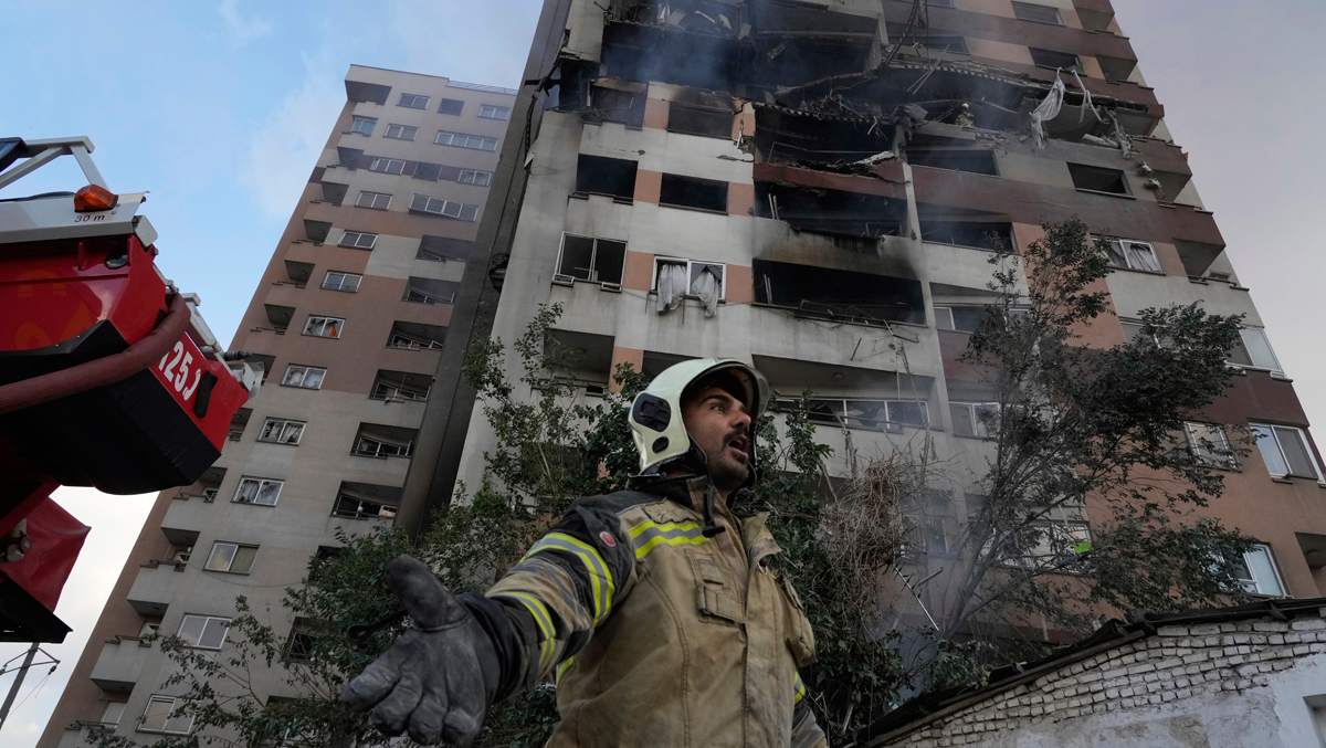 Un bombero junto a uno de los edificios dañados en Teherán tras el bombardeo israelí.