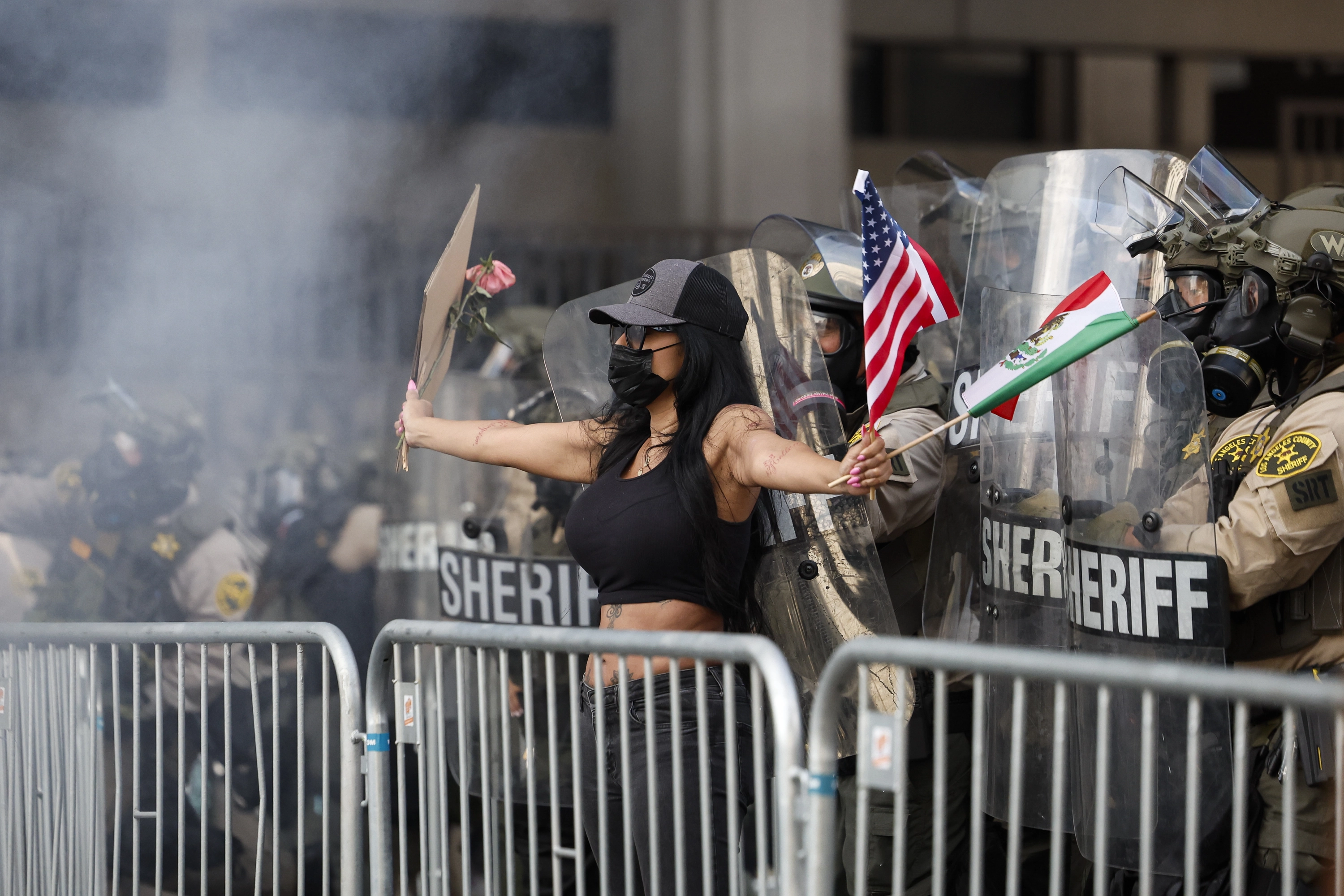 Una manifestante da la espalda a los agentes antidisturbios en las protestas antiTrump en Los Ángeles.