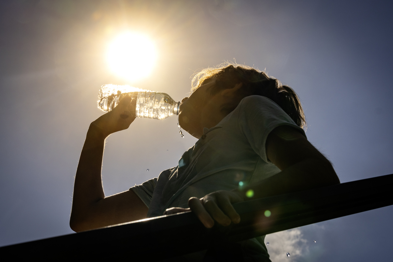 Un joven bebiendo agua para hacer frente al calor.