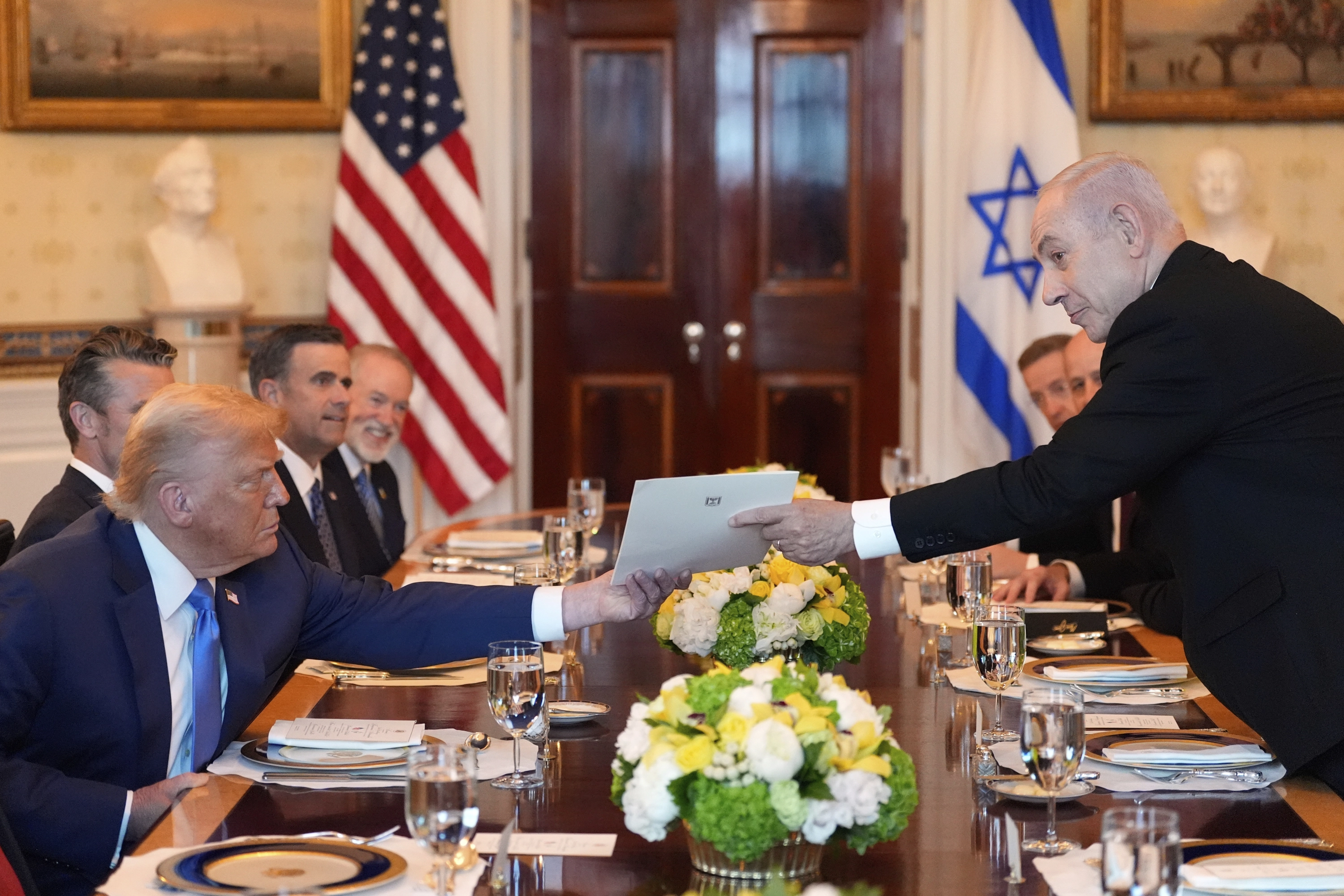 El primer ministro de Israel, Benjamin Netanyahu, a la derecha, entrega al presidente Donald Trump una carpeta durante una reunión en el Salón Azul de la Casa Blanca, el lunes 7 de julio de 2025, en Washington.