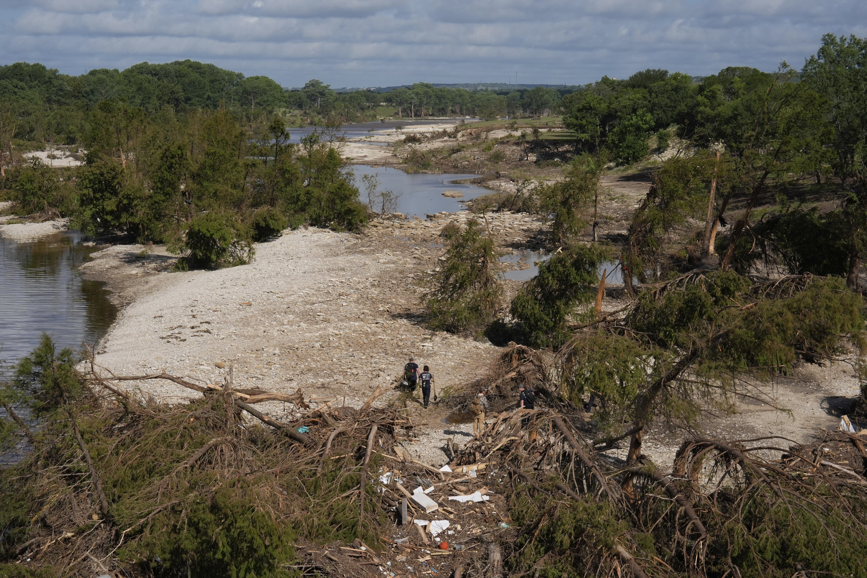 Los equipos de rescate caminan entre los escombros cerca de la orilla del río Guadalupe este martes en Texas.