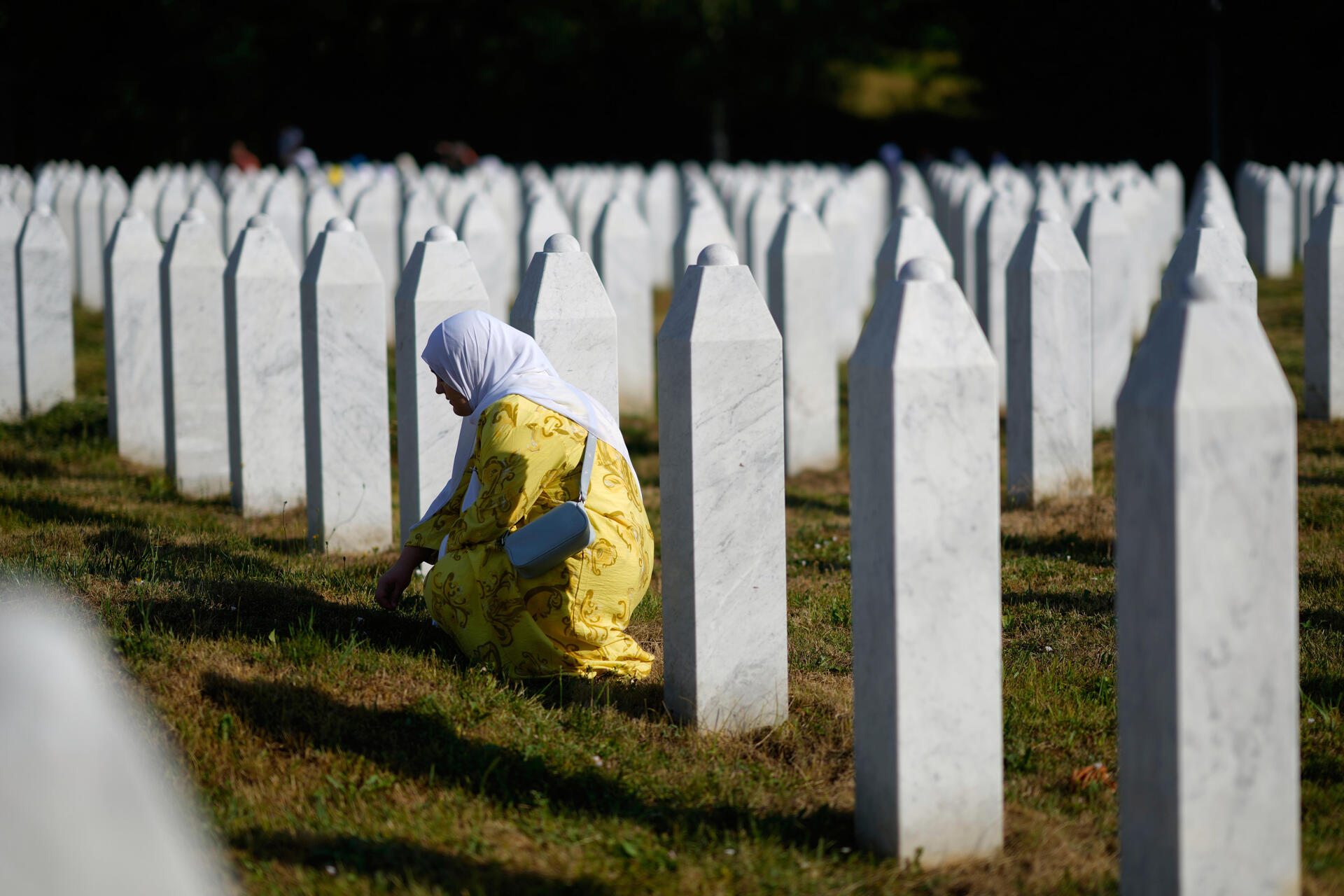 Una mujer, junto a la tumba de un fallecido en Srebrenica.