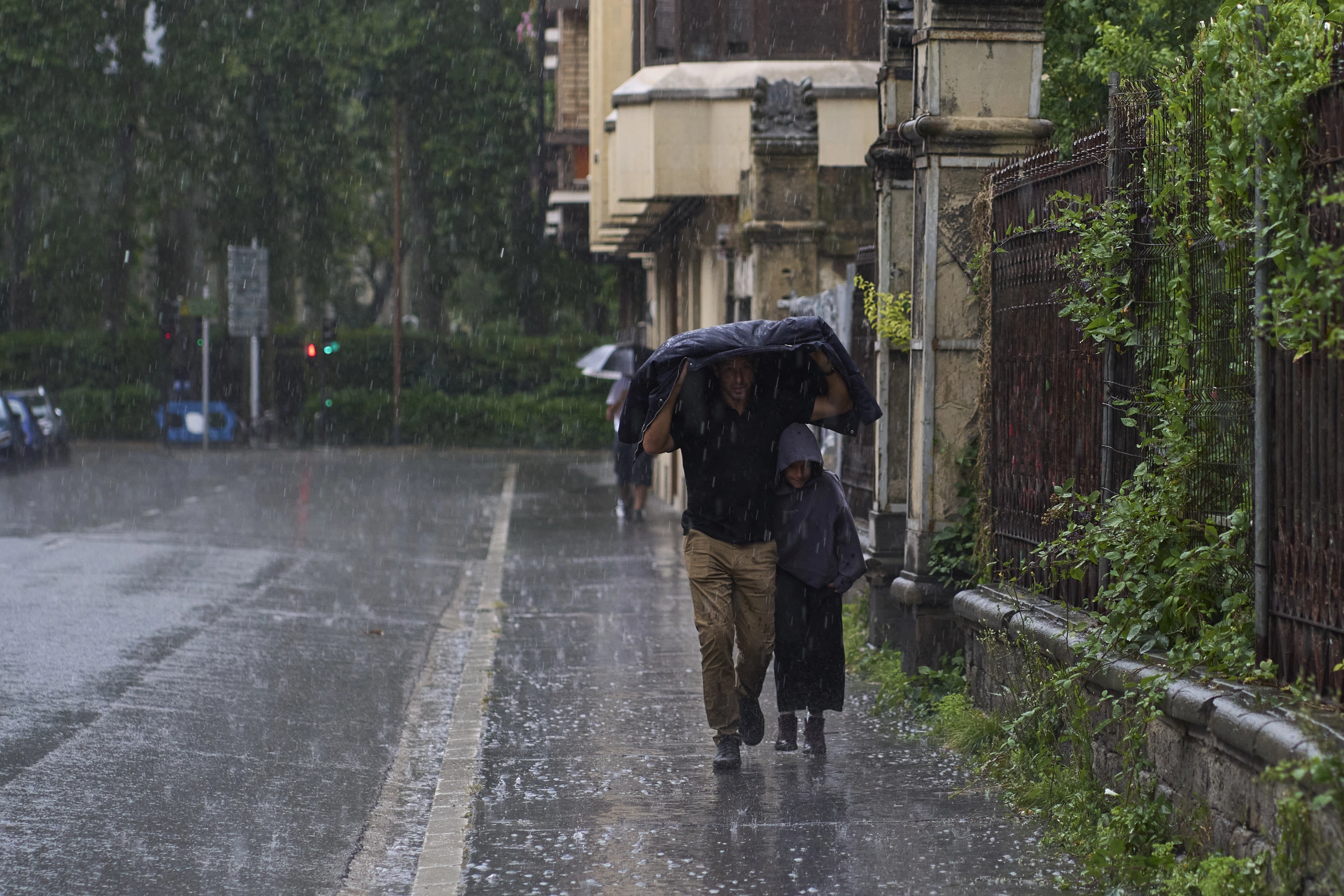 Duas pessoas se abrigam da chuva e o granizo caiu em Vitoria na sexta -feira.