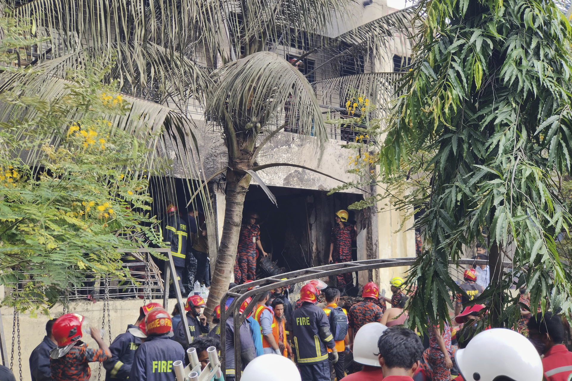 Firemen check the wreckage of a Bangladesh Air Force training aircraft that crashed onto a school campus in Dhaka, Bangladesh, Monday, July 21, 2025. (AP Photo/Mahmud Hossain Opu)